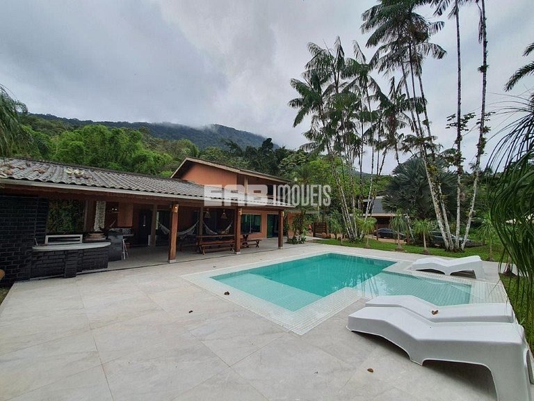 Casa com amplo jardim, piscina e quiosque com churrasqueira