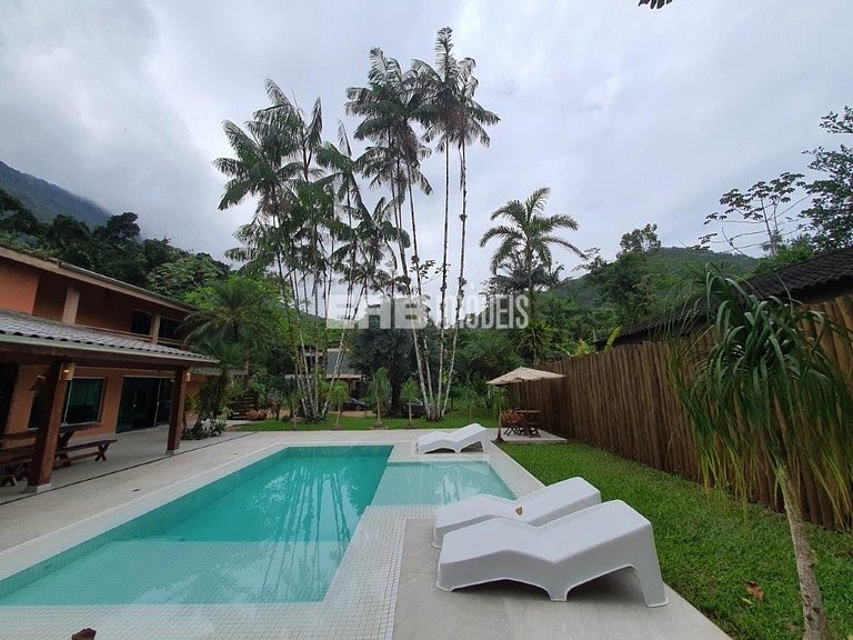 Casa com amplo jardim, piscina e quiosque com churrasqueira