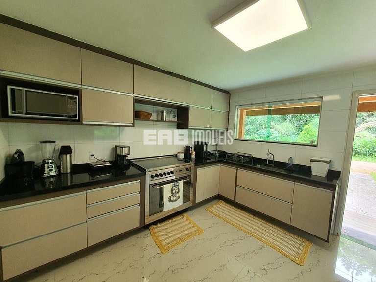 Casa com amplo jardim, piscina e quiosque com churrasqueira