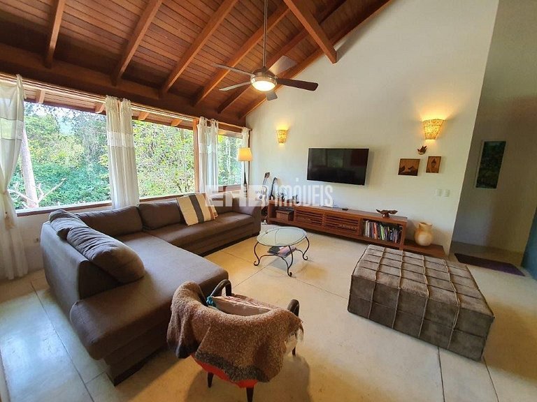 Casa de palafita, cercada por árvores