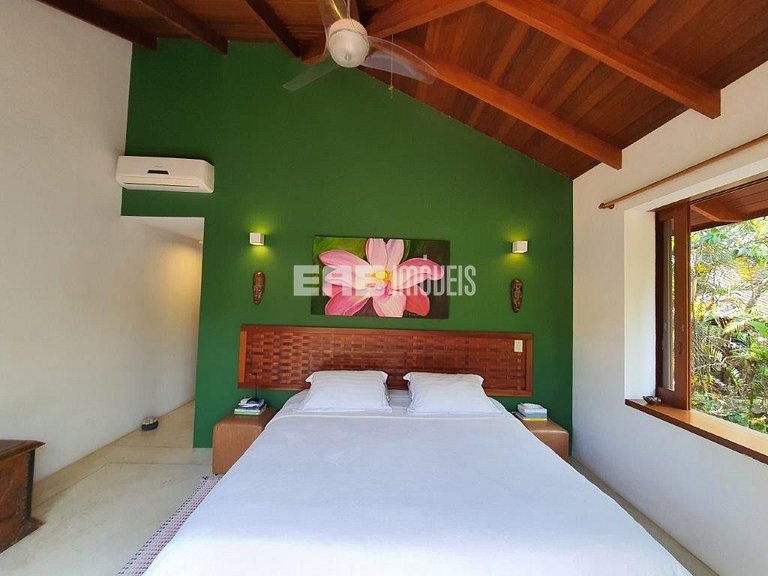 Casa de palafita, cercada por árvores