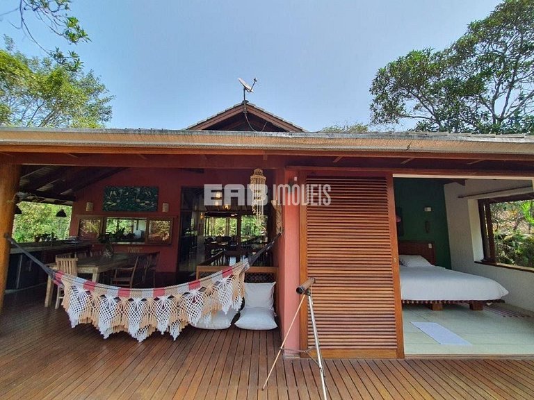 Casa de palafita, cercada por árvores