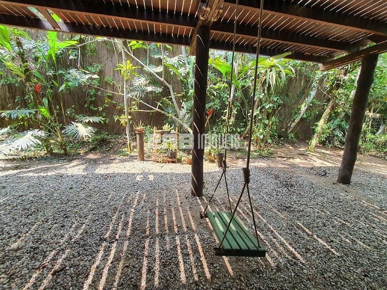 Casa de palafita, cercada por árvores