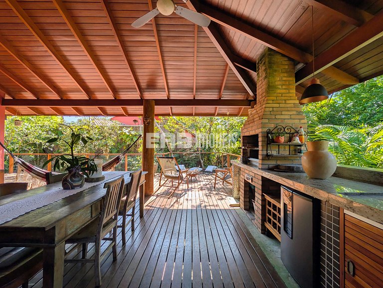 Casa de palafita, cercada por árvores