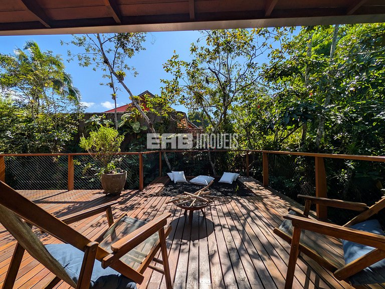 Casa de palafita, cercada por árvores