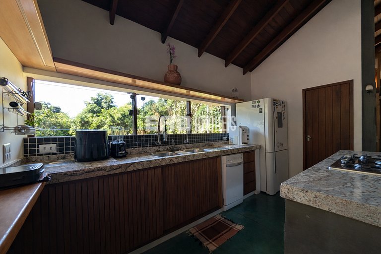 Casa de palafita, cercada por árvores