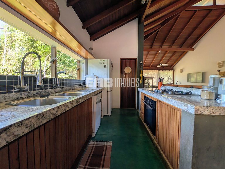 Casa de palafita, cercada por árvores