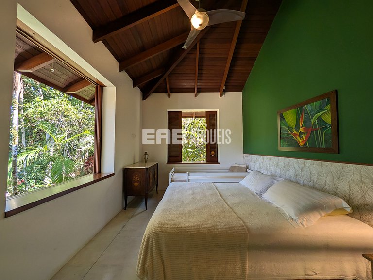 Casa de palafita, cercada por árvores